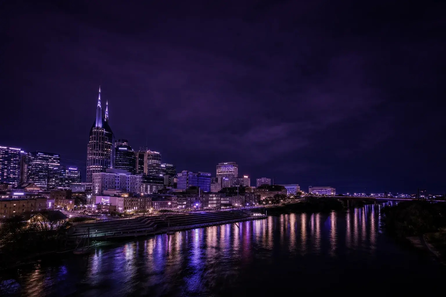 The Nashville skyline at night under a deep purple sky, evoking Velyra's Middle Tennessee roots